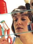 woman looking in medicine cabinet