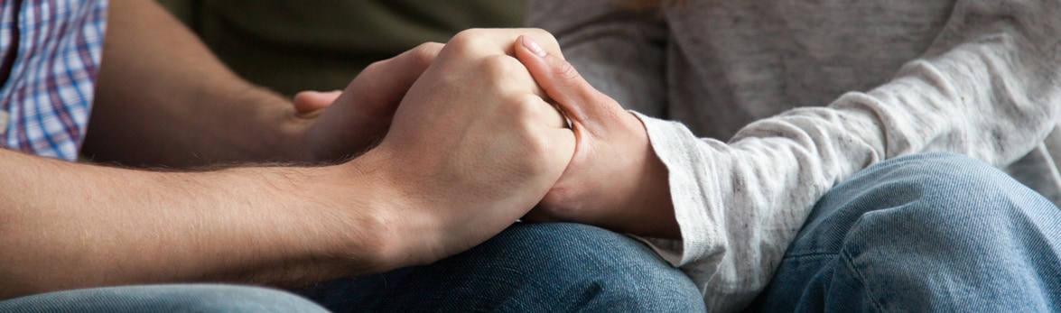 Image of two people clasping hands