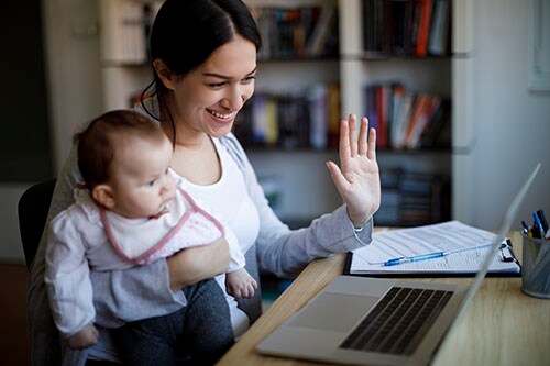 Mother with baby having video conference on laptop