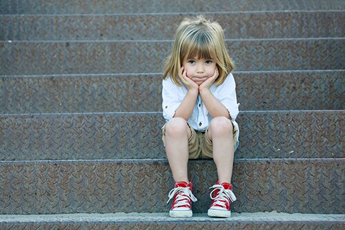 Sad child sitting on staircase