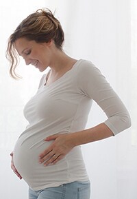 Pregnant woman touching belly.